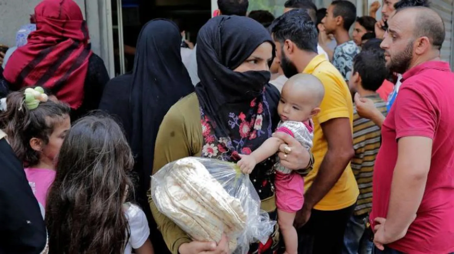 Beyrut yakınlarındaki bir fırından ekmek alıp çıkmayı başaran bir kadın (AFP)