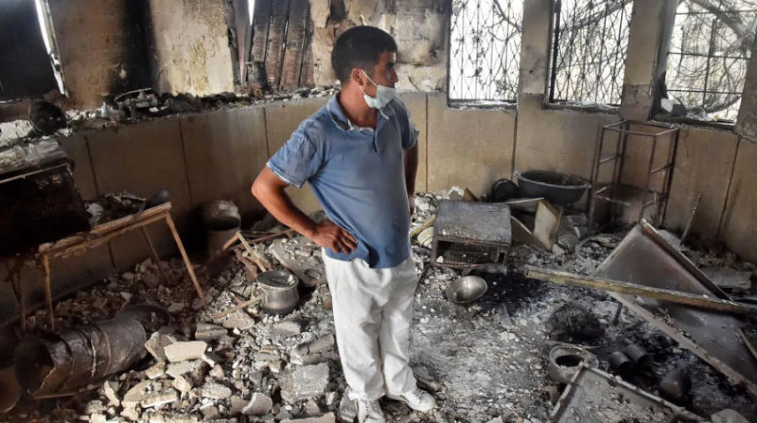 جزائري يتفقد الأضرار بمنزله بسبب حرائق الغابات في منطقة شمال الجزائر (أ.ف.ب)