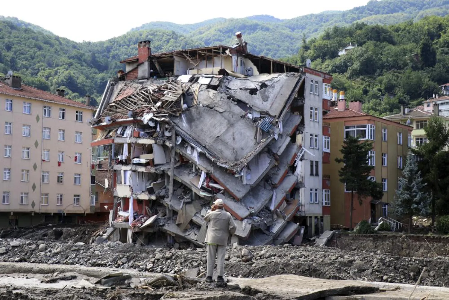 A man looks at destroyed building, in Bozkurt town of Kastamonu province, Turkey, Saturday, Aug. 14, 2021.(AP Photo)
