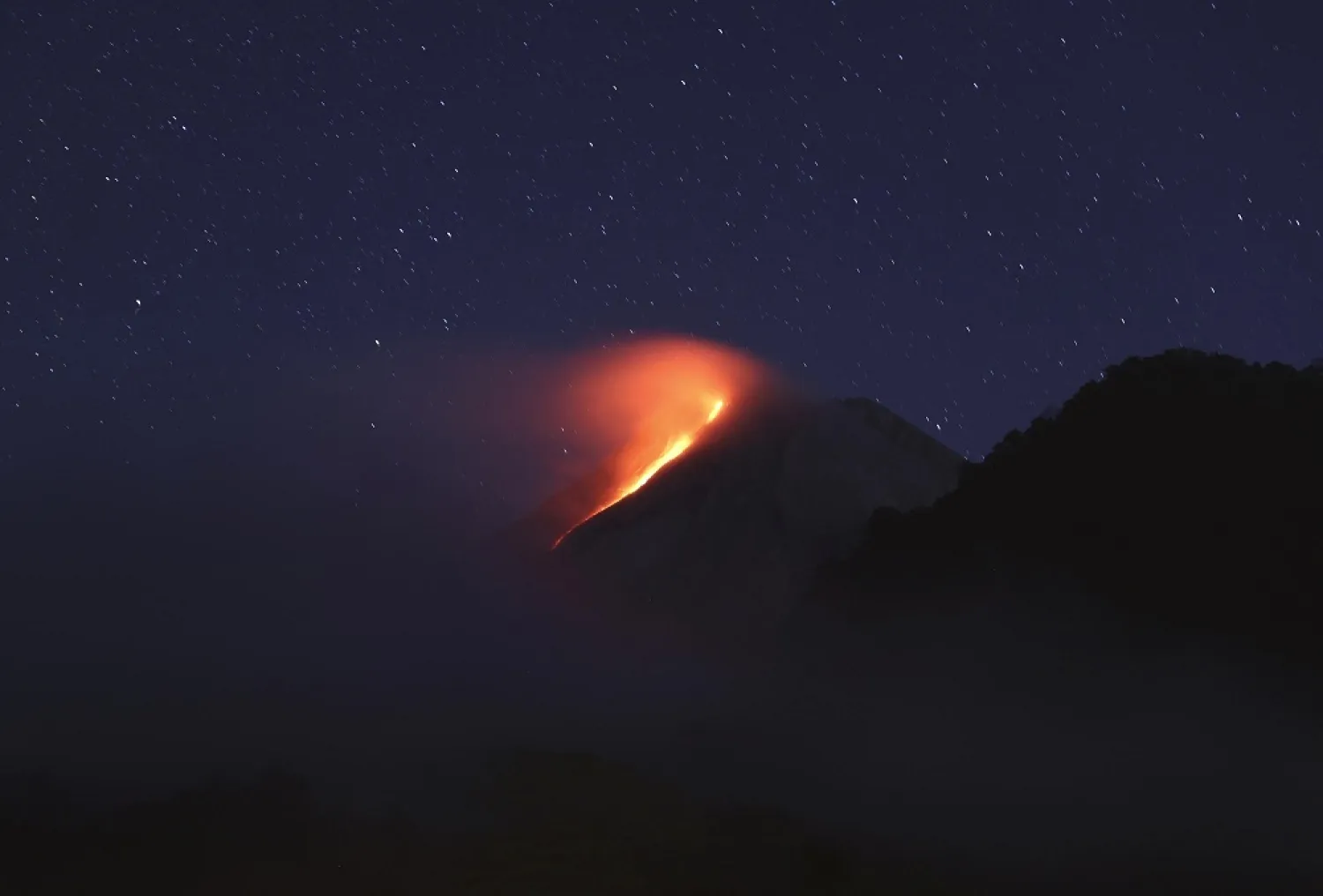 In this photo taken using slow camera shutter speed, hot lava runs down from the crater of Mount Merapi, in Sleman, Yogyakarta, Indonesia, early Wednesday, Aug. 11, 2021. (AP)