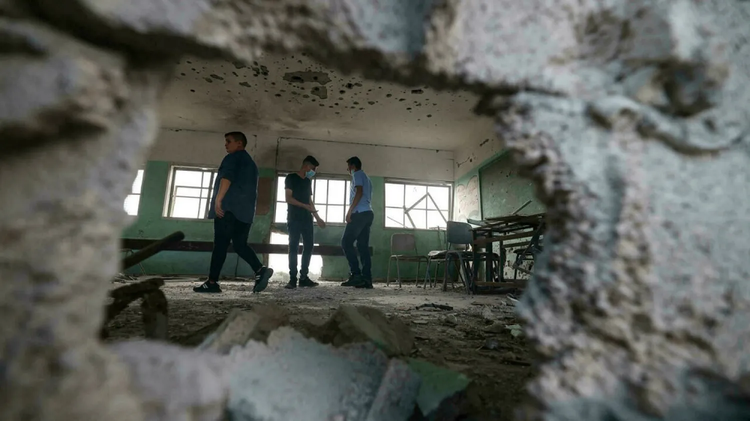 Palestinian students inspect a classroom at a school destroyed during the recent 11-day war between Israel and Hamas, on the first day of the new academic year in Gaza City, on August 16, 2021. (AFP)