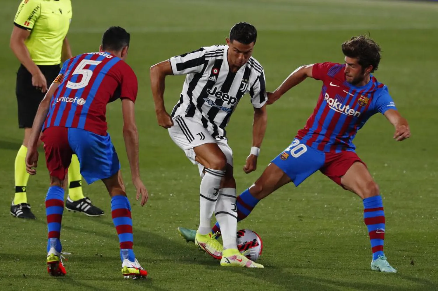 Juventus' Cristiano Ronaldo, center, tries to get past Barcelona's Sergio Busquets, left and Sergi Roberto during the Joan Gamper trophy soccer match between FC Barcelona and Juventus at the Estadi Johan Cruyff in Barcelona, Spain, Sunday, Aug. 8, 2021. (AP Photo/Joan Monfort)
