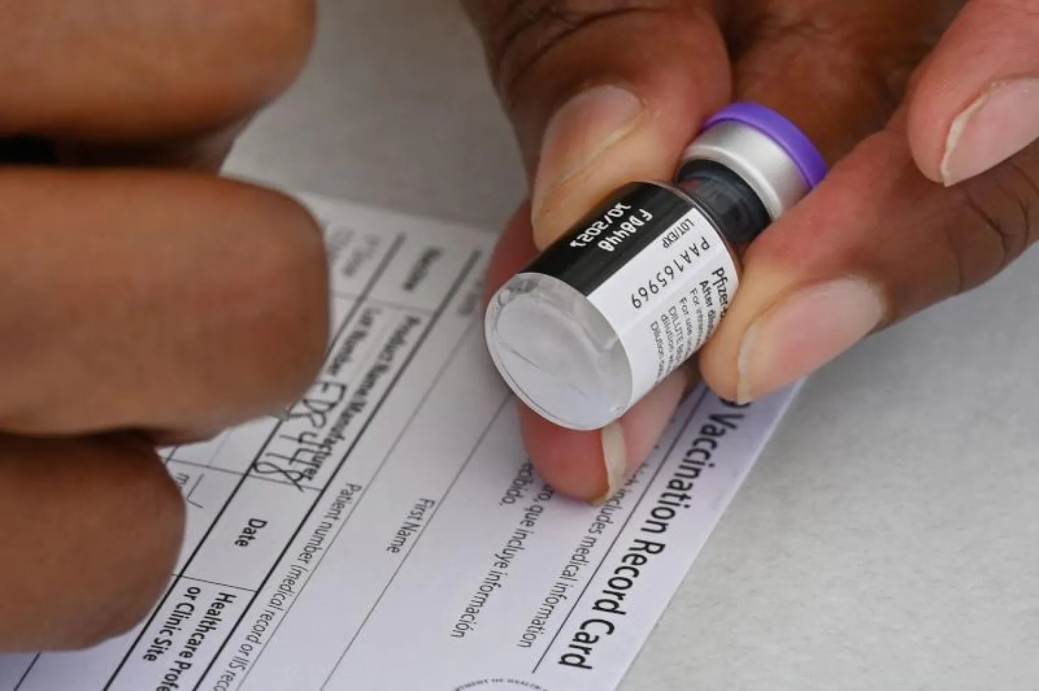 موظف صحي يقوم بكتابة معلومات على بطاقة تلقيح في لوس أنجليس (أ.ف.ب)