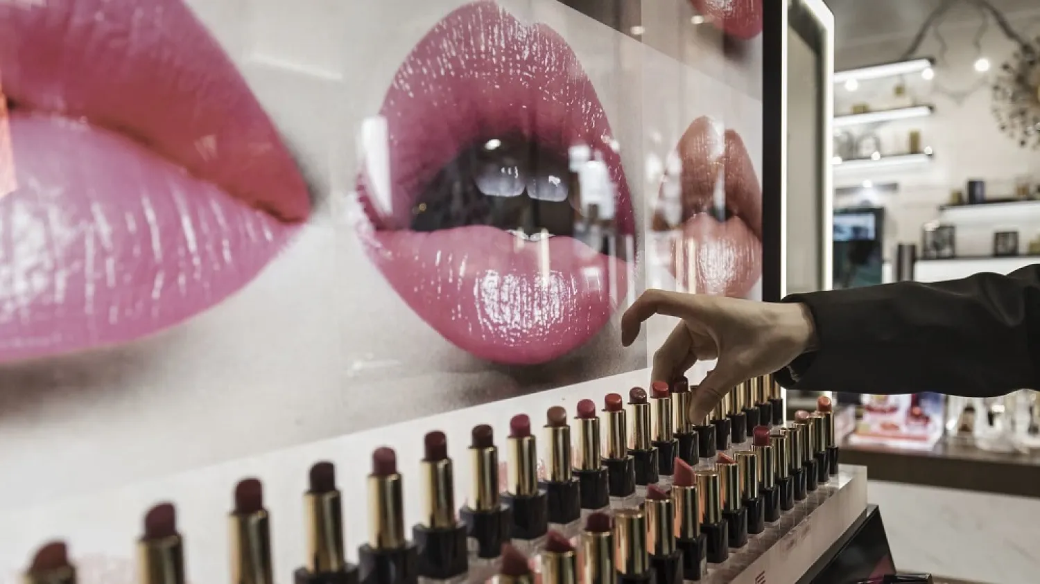 A sales assistant arranges lipsticks at an Estee Lauder store. (Getty Images)