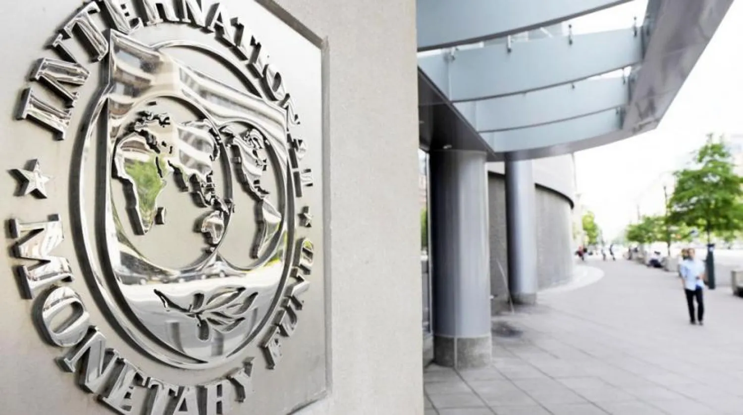 Pedestrians walk past the International Monetary Fund headquarters’ complex in Washington. (AP)
