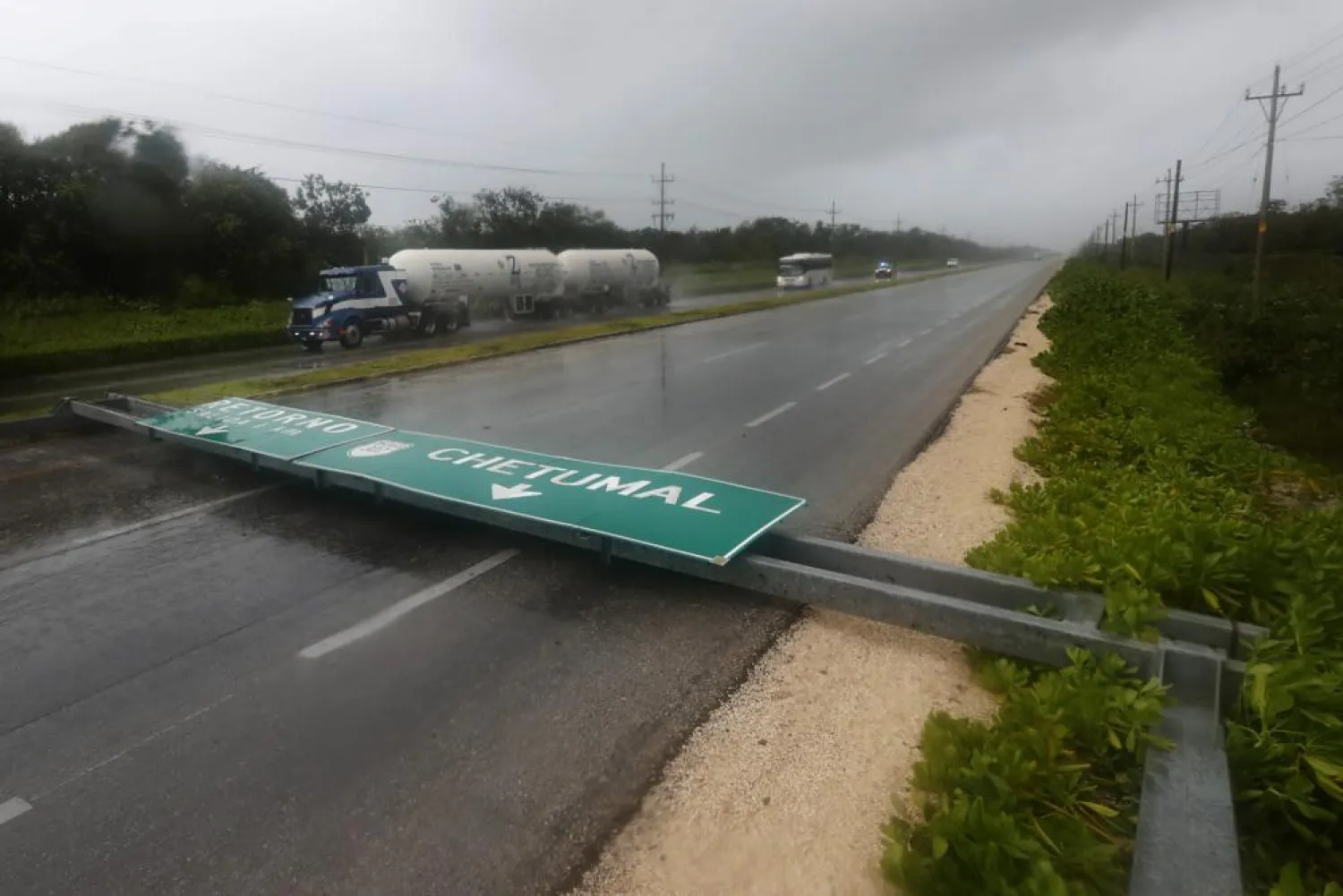 A road sign brought down by the winds of Hurricane Grace straddles one lane of a highway in Tulum, Quintana Roo state, Mexico, Thursday, Aug. 19, 2021. (AP Photo/Marco Ugarte)