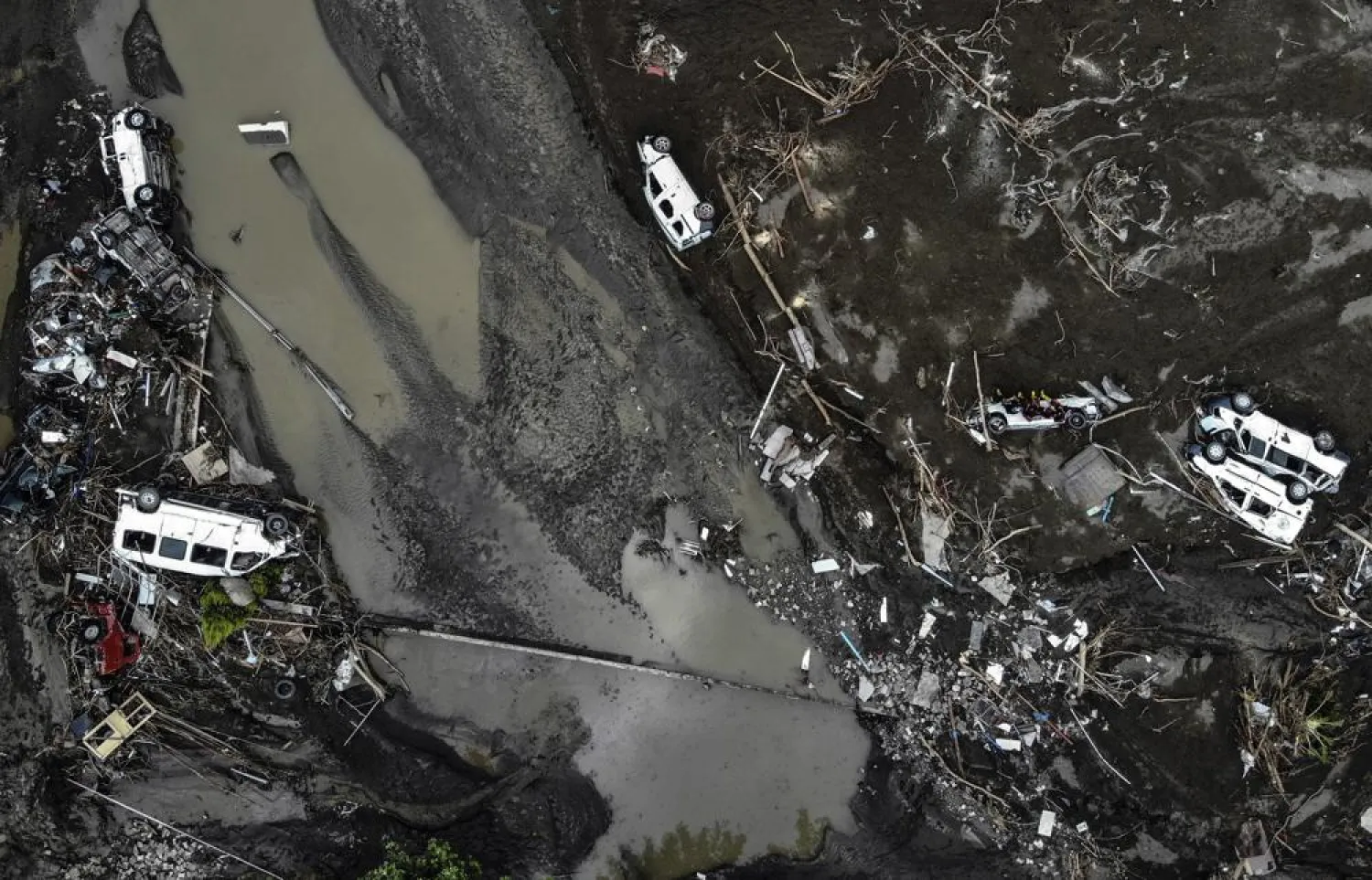 An aerial photo shows overturned cars among destruction in a mud-covered street in Bozkurt town of Kastamonu province, Turkey, Saturday, Aug. 14, 2021. (AP)