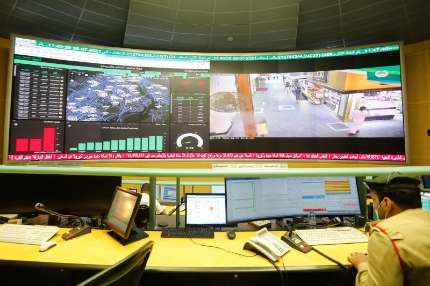 ضابط شرطة ينظر على جهاز الكمبيوتر الخاص به في مركز القيادة والتحكم بشرطة دبي (رويترز)
