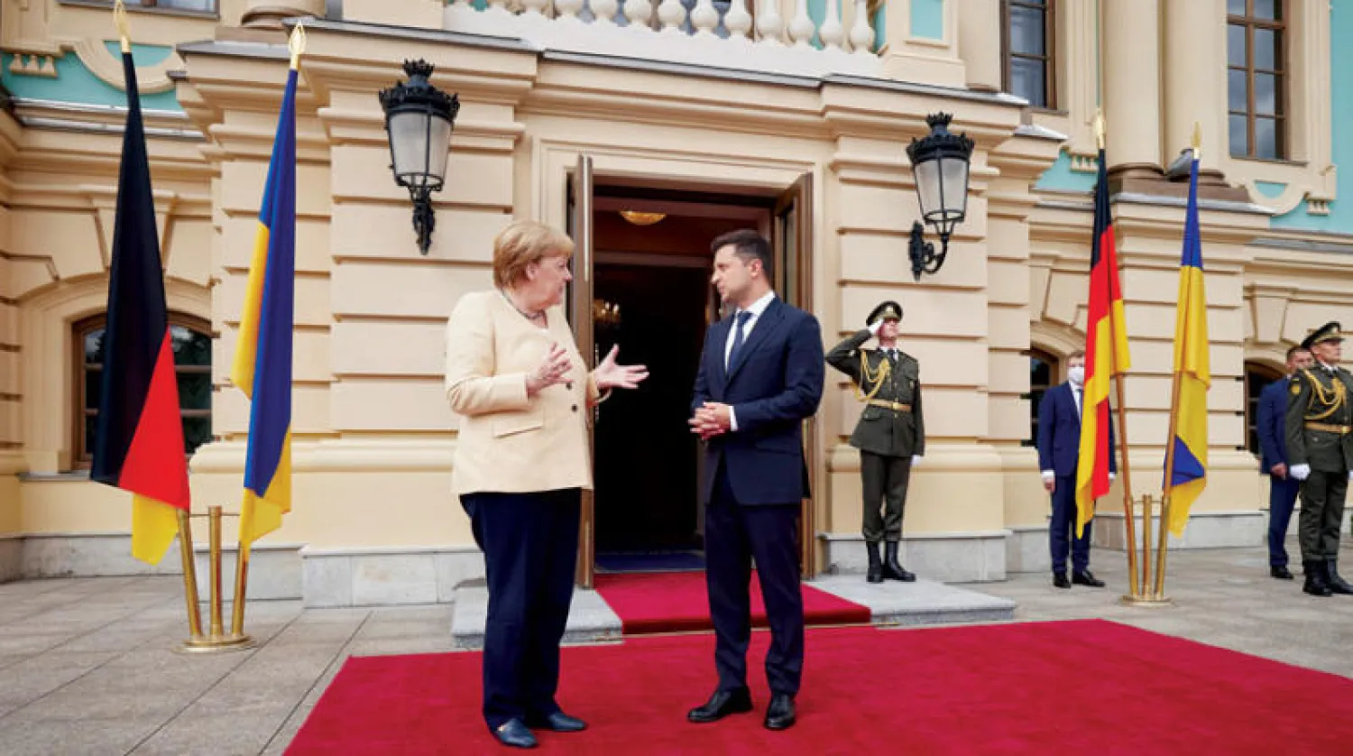 زيلينسكي لدى استقباله ميركل في كييف أمس (إ.ب.أ)