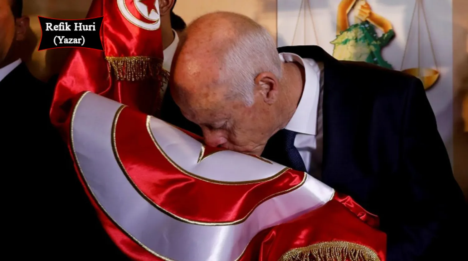 13 Ekim 2019'da Tunus cumhurbaşkanlığı seçimlerinin sonuçlarının açıklanmasının ardından Kays Said ülkesinin bayrağını öpüyor (Reuters)