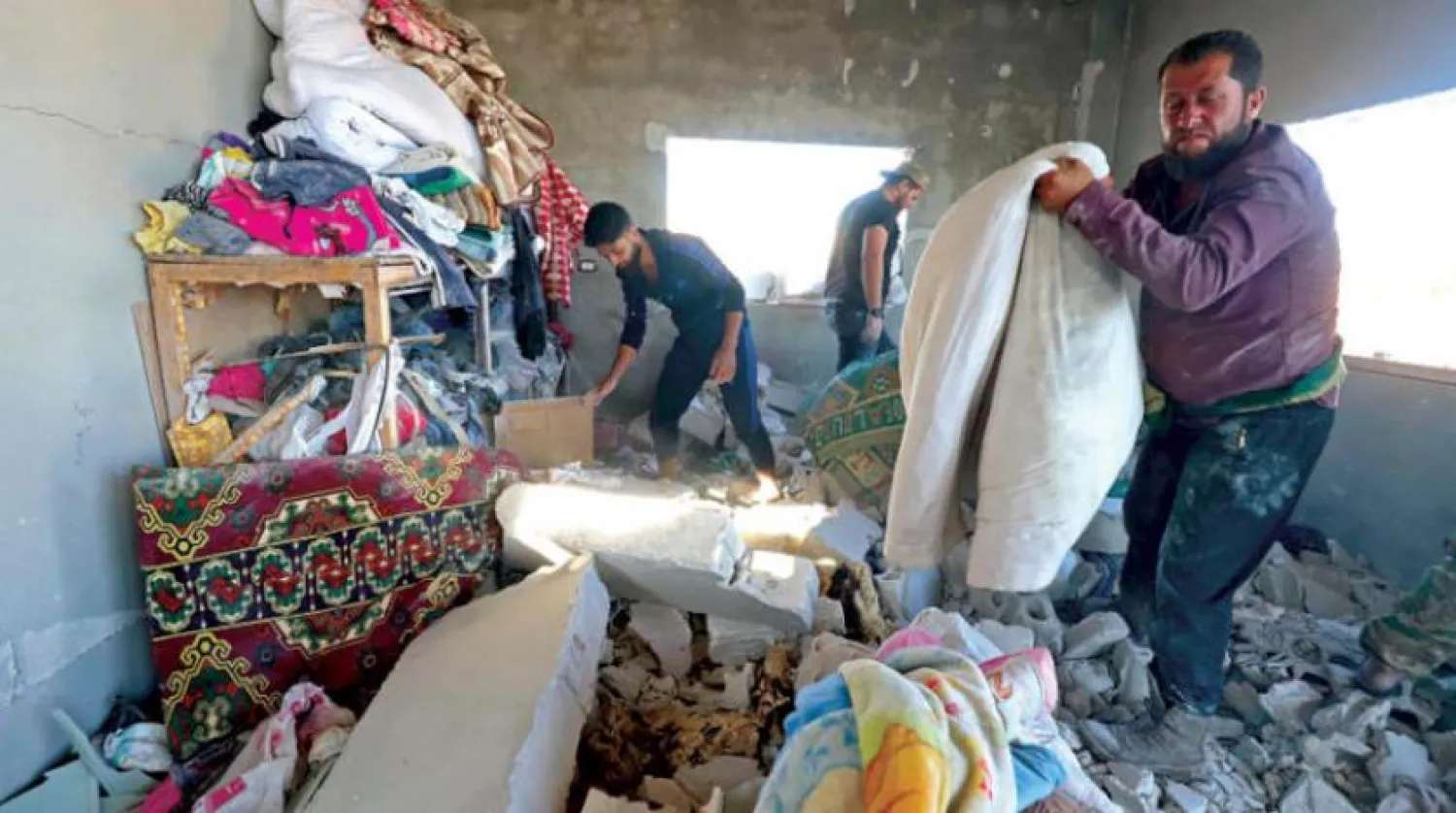 20 Ağustos’ta rejim güçlerinin bombardımanlarının ardından İdlib kırsalındaki siviller eşyalarını kontrol ediyor (AFP)