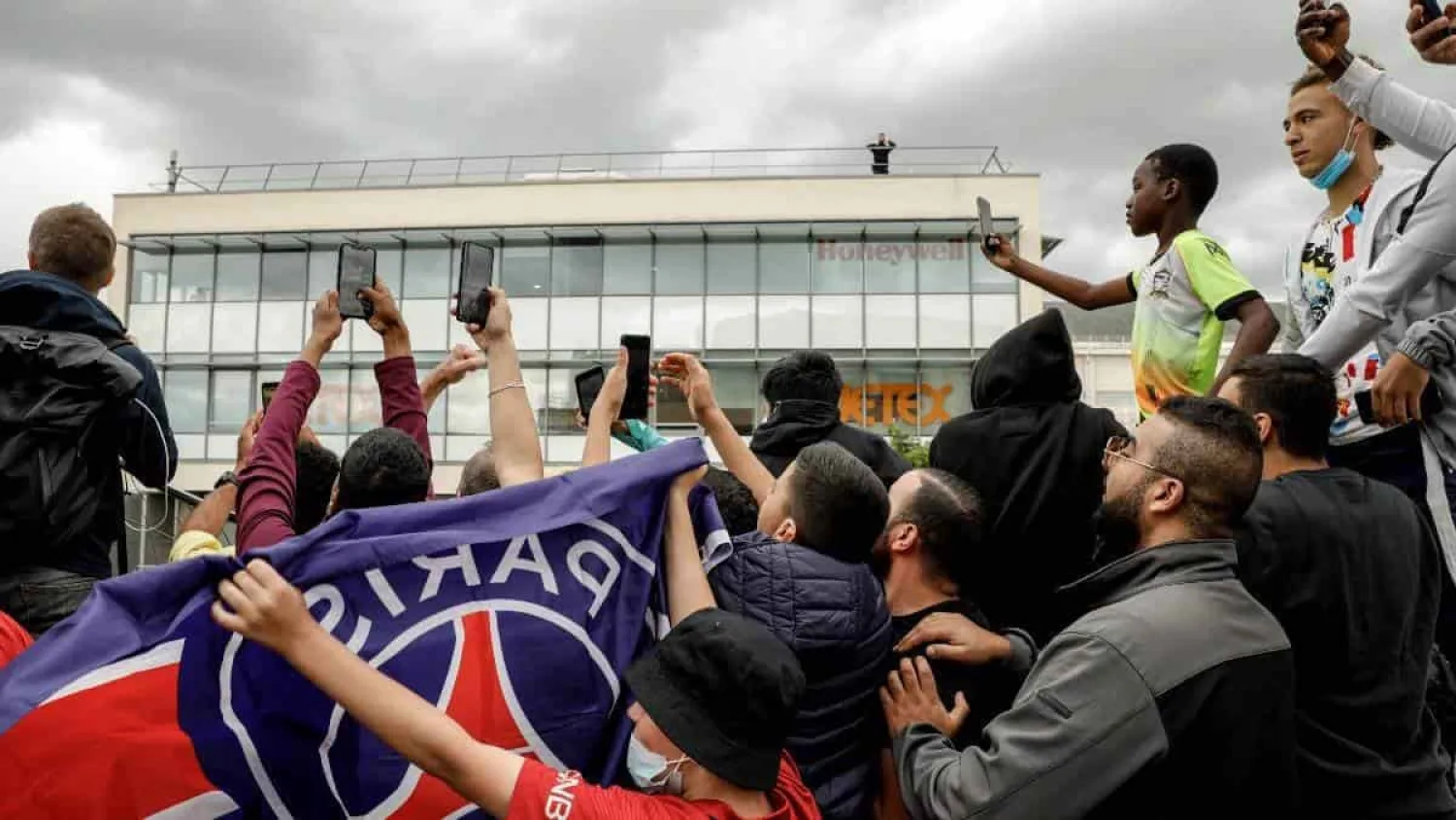 Supporters try to spot an aircraft that just landed as they gather outside Le Bourget airport, north of Paris, expecting Argentinian football player Lionel Messi to arrive, on August 9, 2021. © Geoffroy van der Hasselt, AFP

