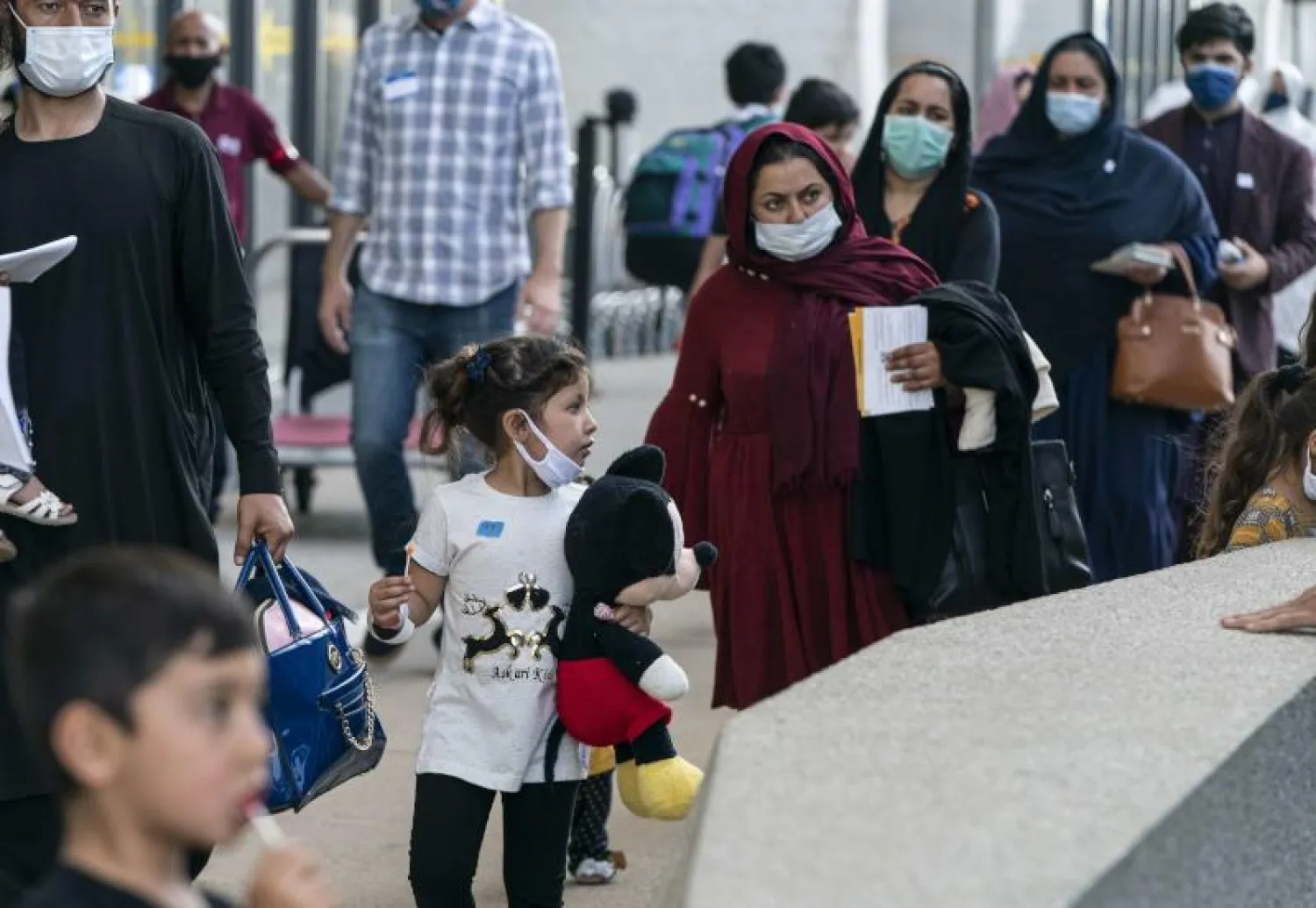 مواطنون أفغان عند وصولهم إلى مطار دالاس الأميركي (أ.ف.ب)