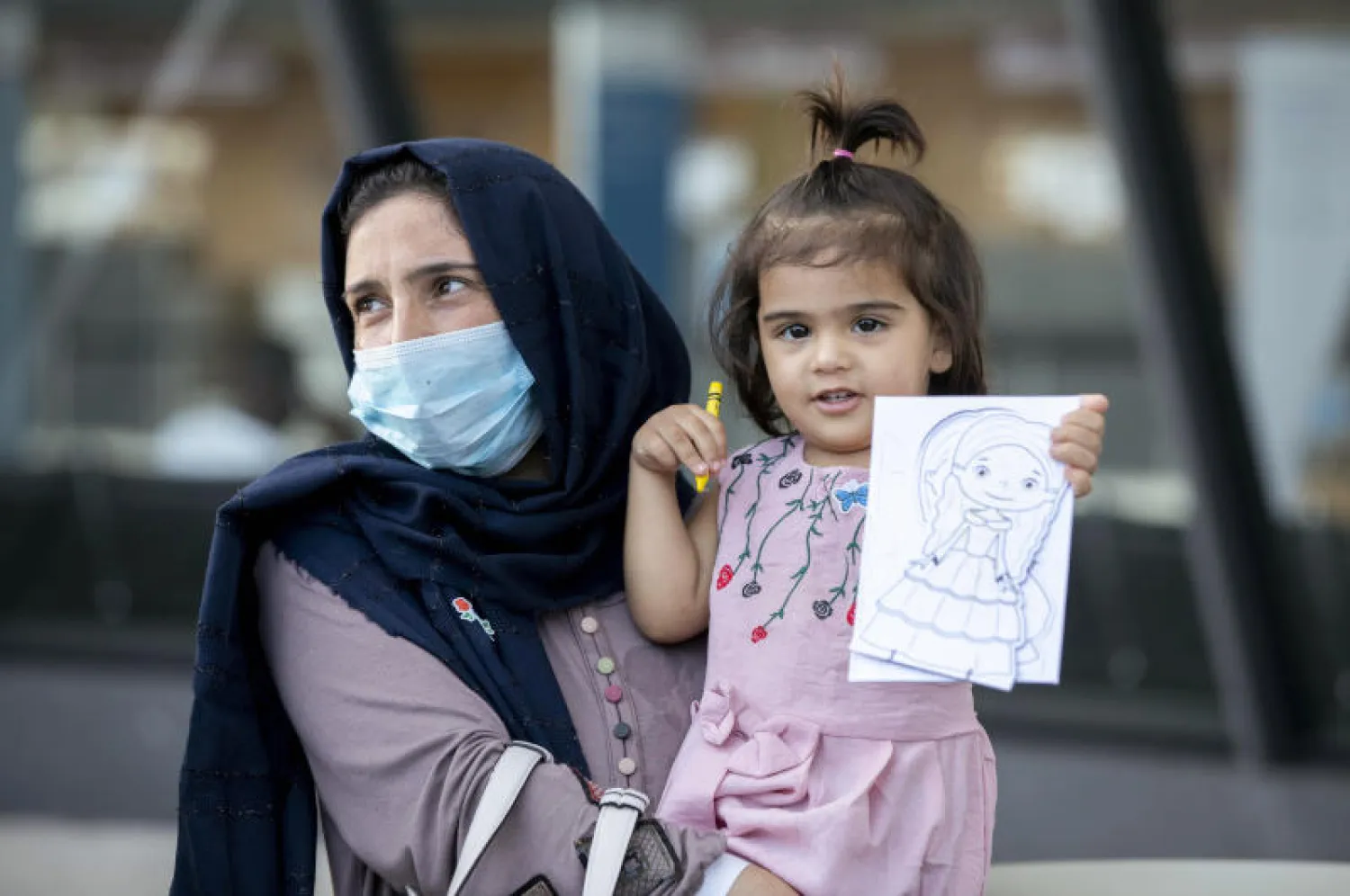 سيدة وطفلتها من كابل في مطار واشنطن الدولي بعد إجلائهما من أفغانستان (أ.ب)