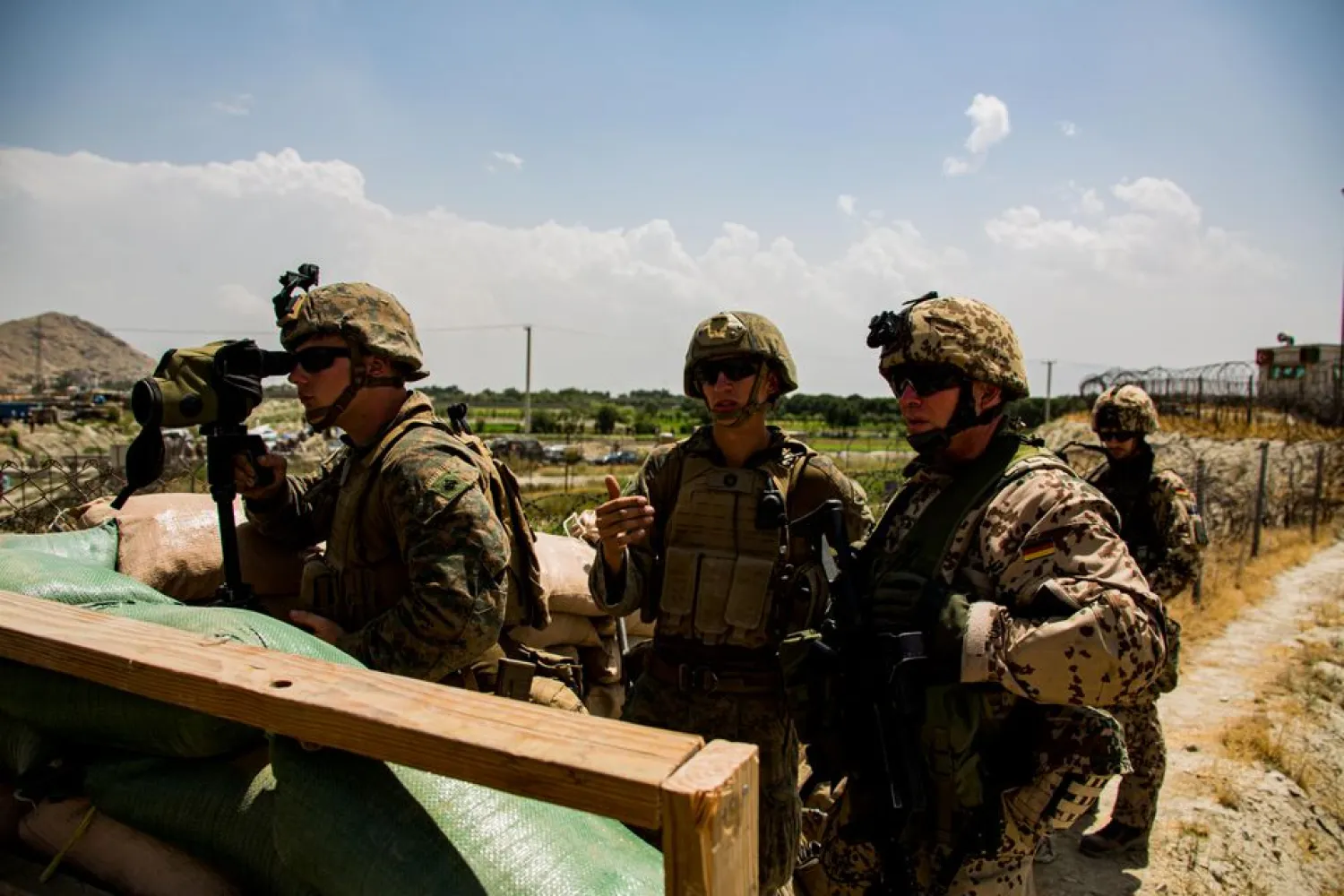 US Marines and German service member watch an entry gate during an evacuation at Hamid Karzai International Airport, Kabul, Afghanistan, August 28, 2021. (US Marine Corps/Cpl. Davis Harris/Handout via Reuters)