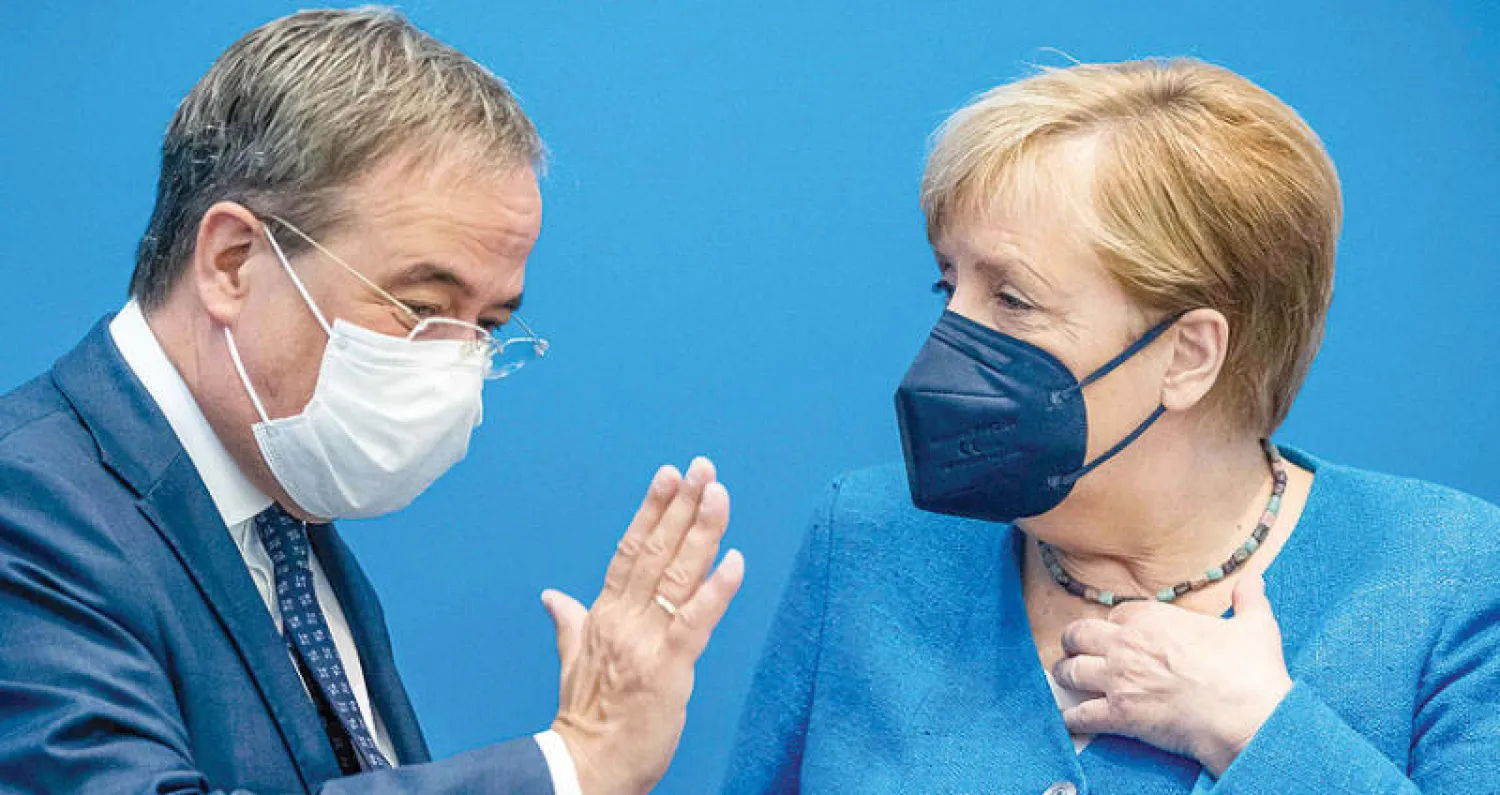 ميركل مع خليفتها لاشيت الذي لم ينجح بقلب استطلاعات الرأي وإعادة حزبه إلى الطليعة (أ.ف.ب)