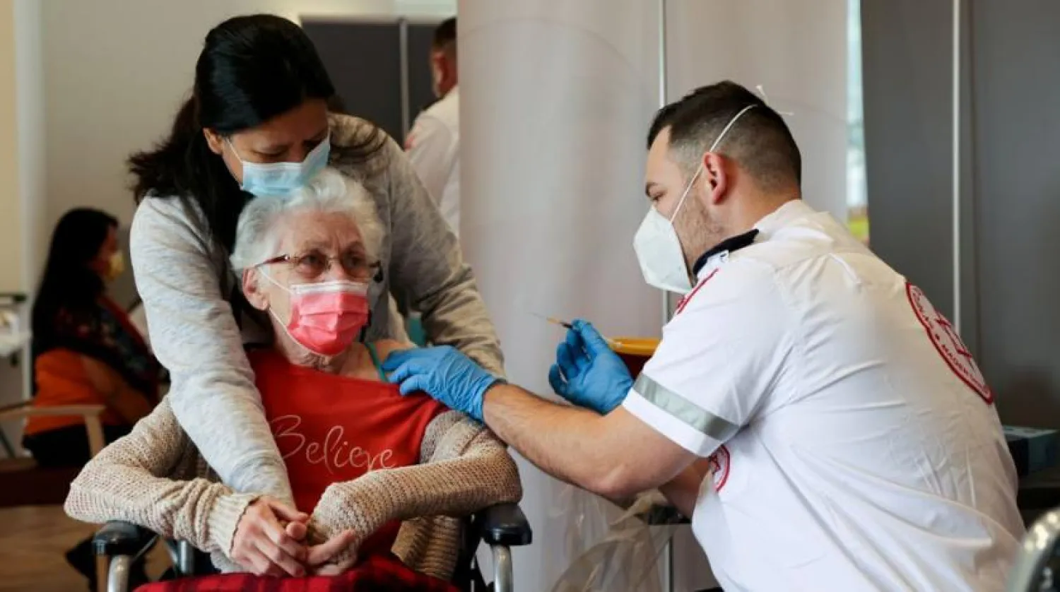 An elderly woman receives a booster shot of her vaccination against the coronavirus disease (COVID-19) at an assisted living facility, in Netanya, Israel January 19, 2021. (Reuters)
