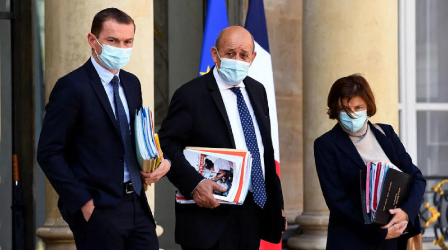 وزير الخارجية الفرنسي جان إيف لودريان يتوسط وزيرة الدفاع فلورنس بارلي  ووزير العمل والحسابات العامة أوليفييه دوسوبت لدى مغادرة الإليزيه أمس (أ.ف.ب)