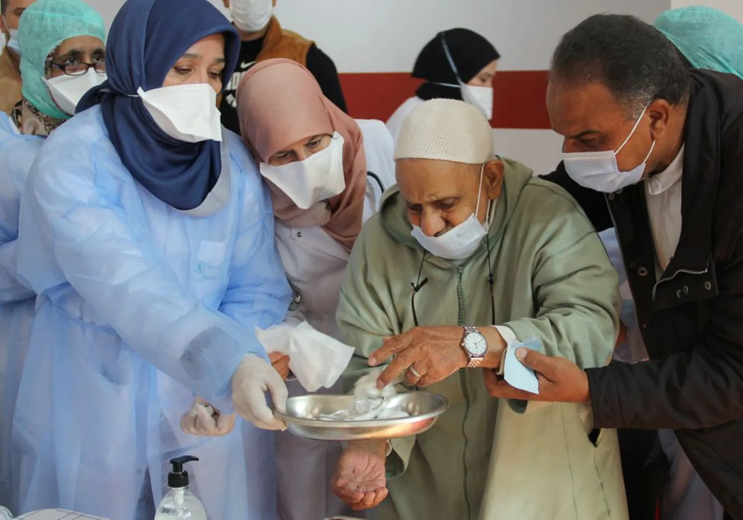 Healthcare workers assist an elderly man after he received the COVID-19 vaccine, during a national coronavirus vaccination campaign, in Sale, Morocco January 29, 2021. (Reuters)