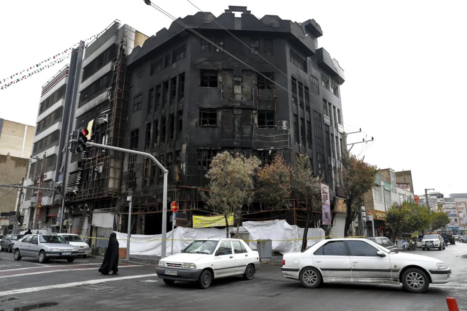 FILE - In this Wednesday, Nov. 20, 2019 file photo, traffic passes a building that was set ablaze in Tehran, Iran. AP Photo/Ebrahim Noroozi, File)
