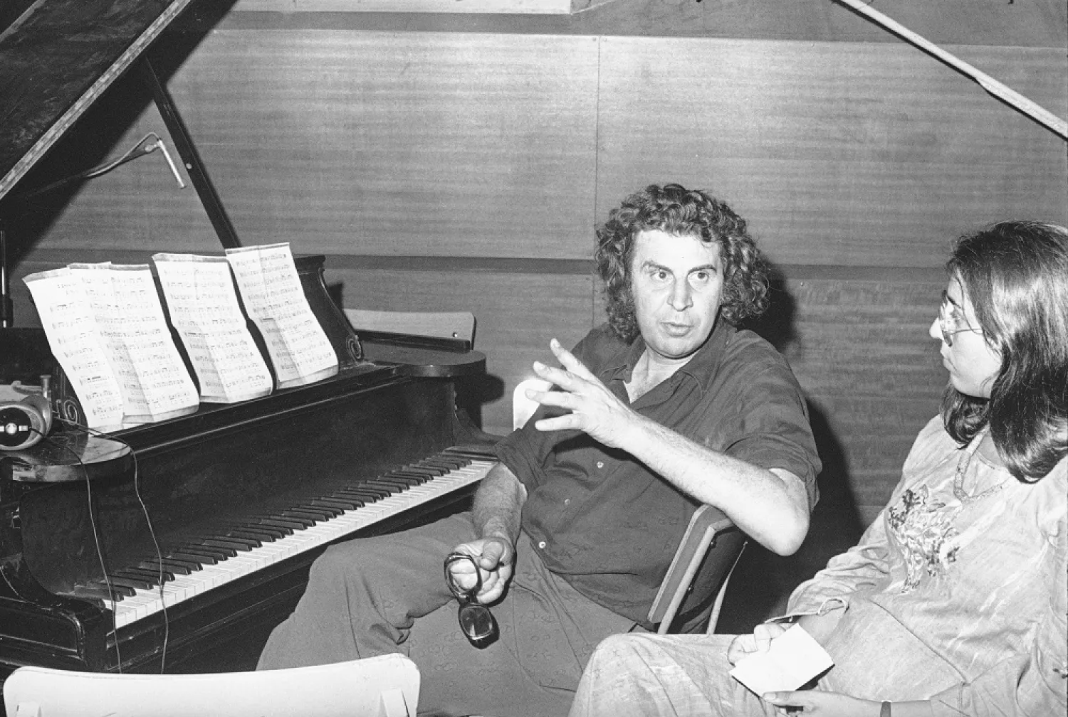 Greek composer Mikis Theodorakis (C) talks with Greece’s top singer Maria Farandouri during a break at the Athens recording studio, Athens, Greece, Aug. 21, 1974. (AP)