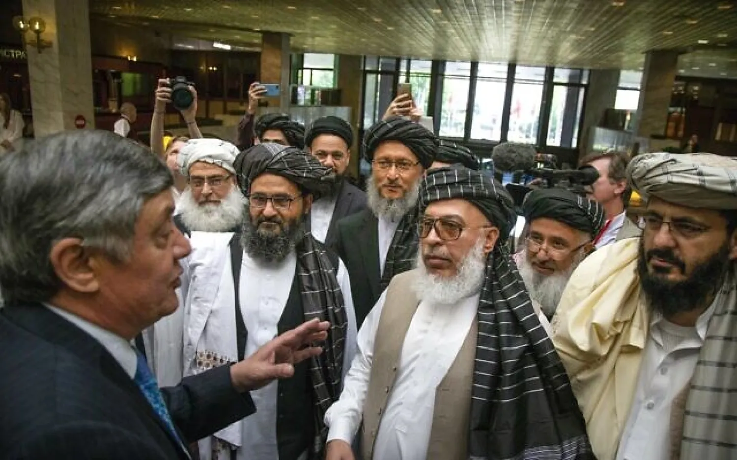 In this Tuesday, May 28, 2019 file photo, Russian presidential envoy to Afghanistan Zamir Kabulov, left, speaks to Mullah Abdul Ghani Baradar, the Taliban group's top political leader, third left, Sher Mohammad Abbas Stanikzai, the Taliban's chief negotiator, third right, and other members of the Taliban delegation prior to their talks in Moscow, Russia. (AP Photo/Alexander Zemlianichenko, File)
