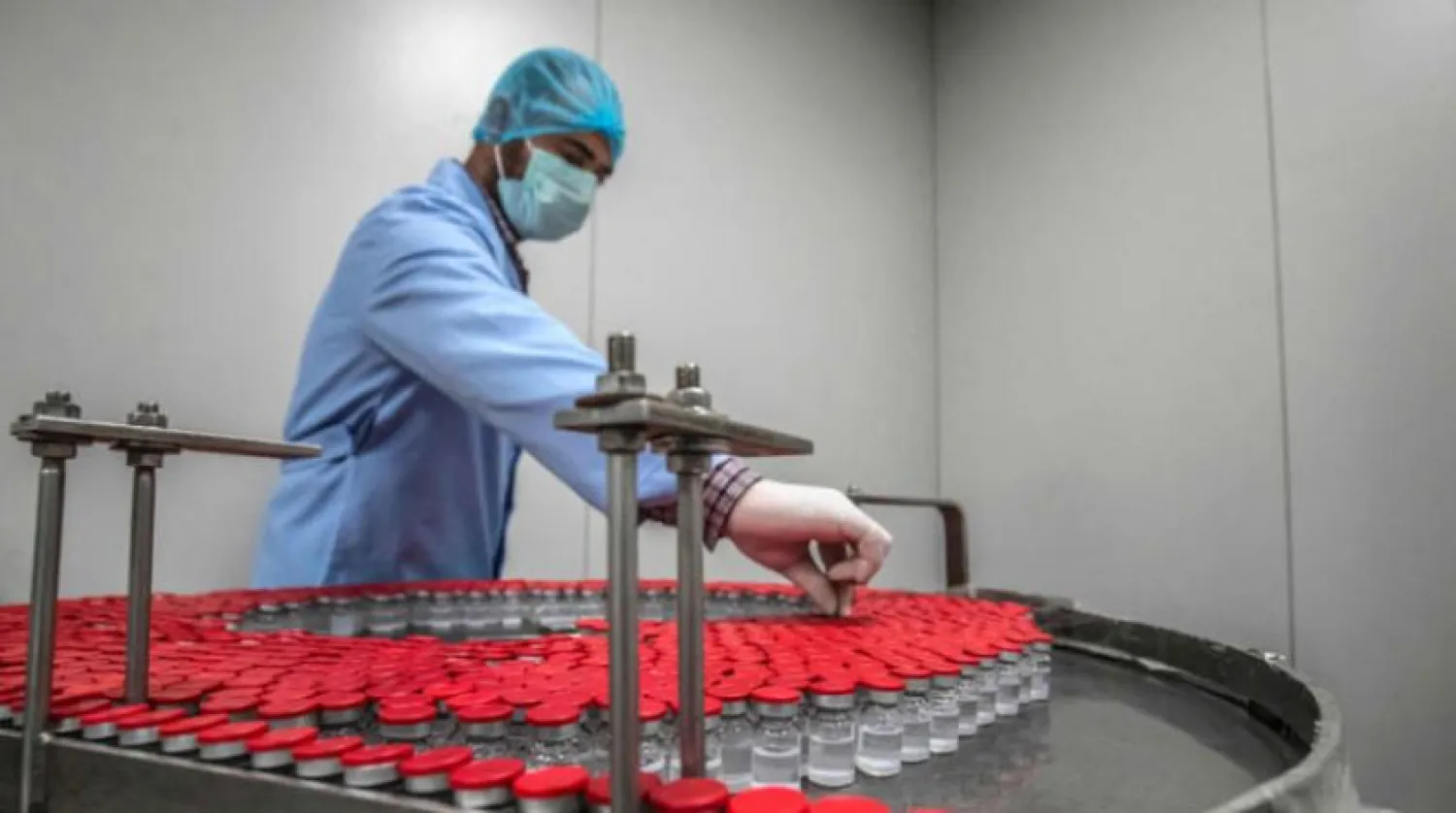 Kahire'deki Vacsera şirketinde Sinovac aşısının üretimini denetleyen bir çalışan (AFP)