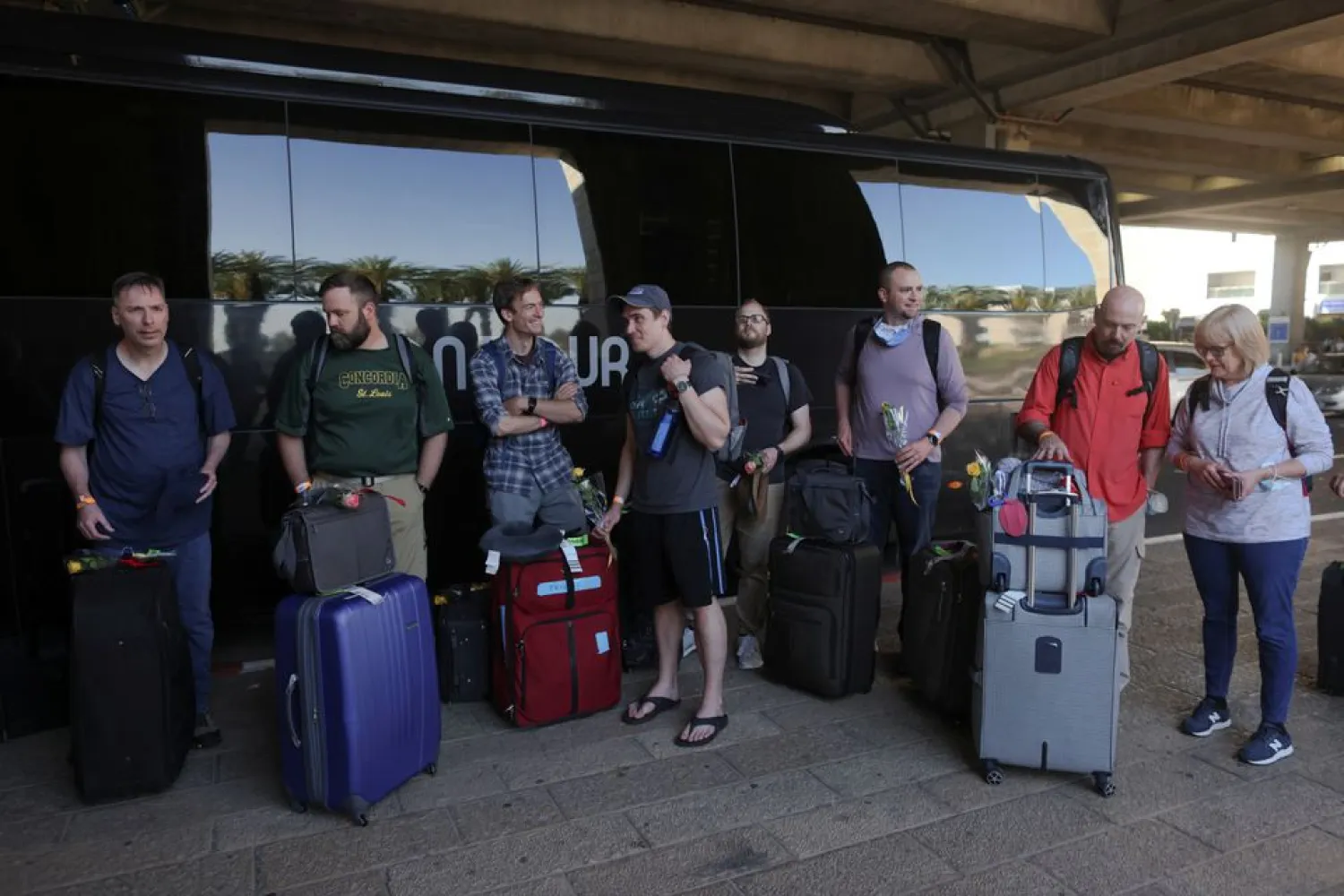 Tourists wait next to a bus outside Ben Gurion International Airport after entering Israel by plane, as coronavirus disease (COVID-19) restrictions ease, in Lod, near Tel Aviv, Israel, May 27, 2021. REUTERS/Ronen Zvulun