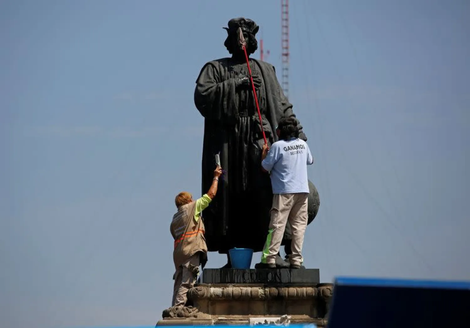 Workers clean the statue of Italian explorer Cristobal Colon, also known as Christopher Columbus, in Mexico City. (Reuters)