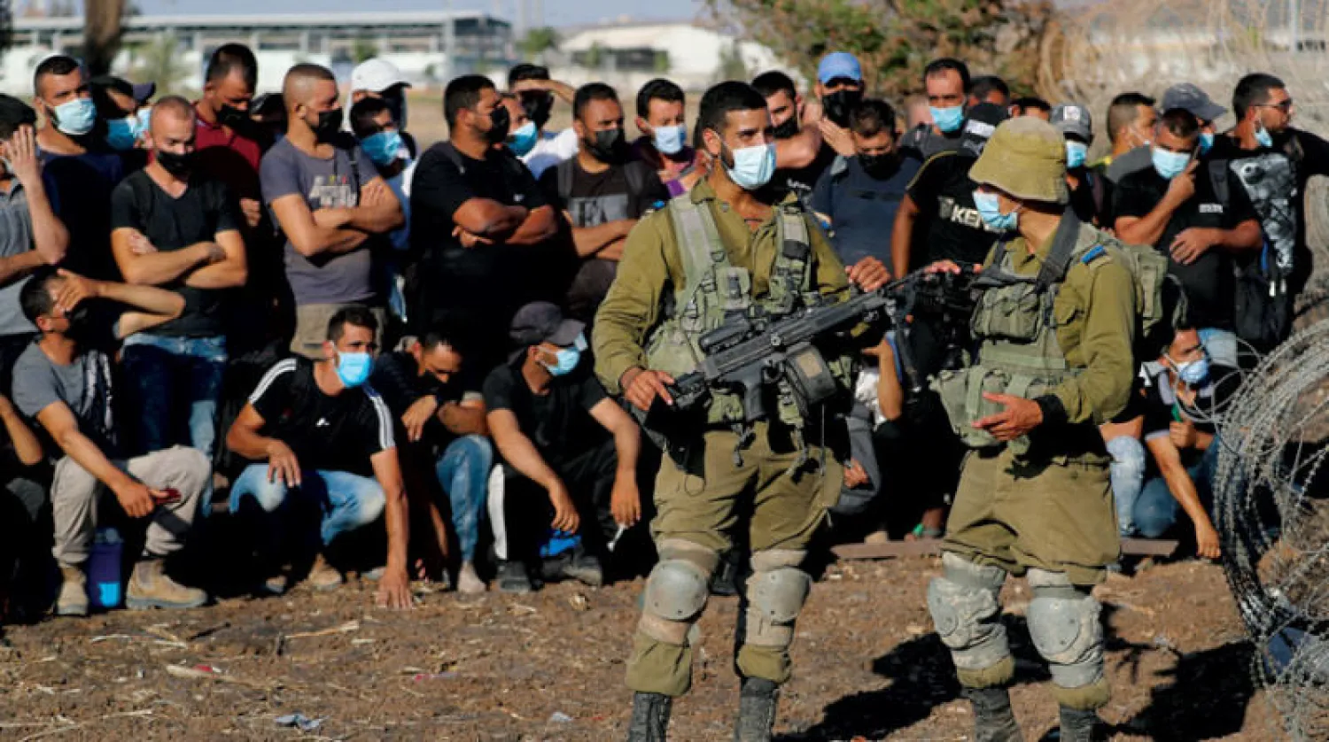 تجمع فلسطينيين قرب معبر مقيبلة بالضفة بينما تجري قوات الأمن الإسرائيلية عمليات تفتيش واسعة (رويترز)