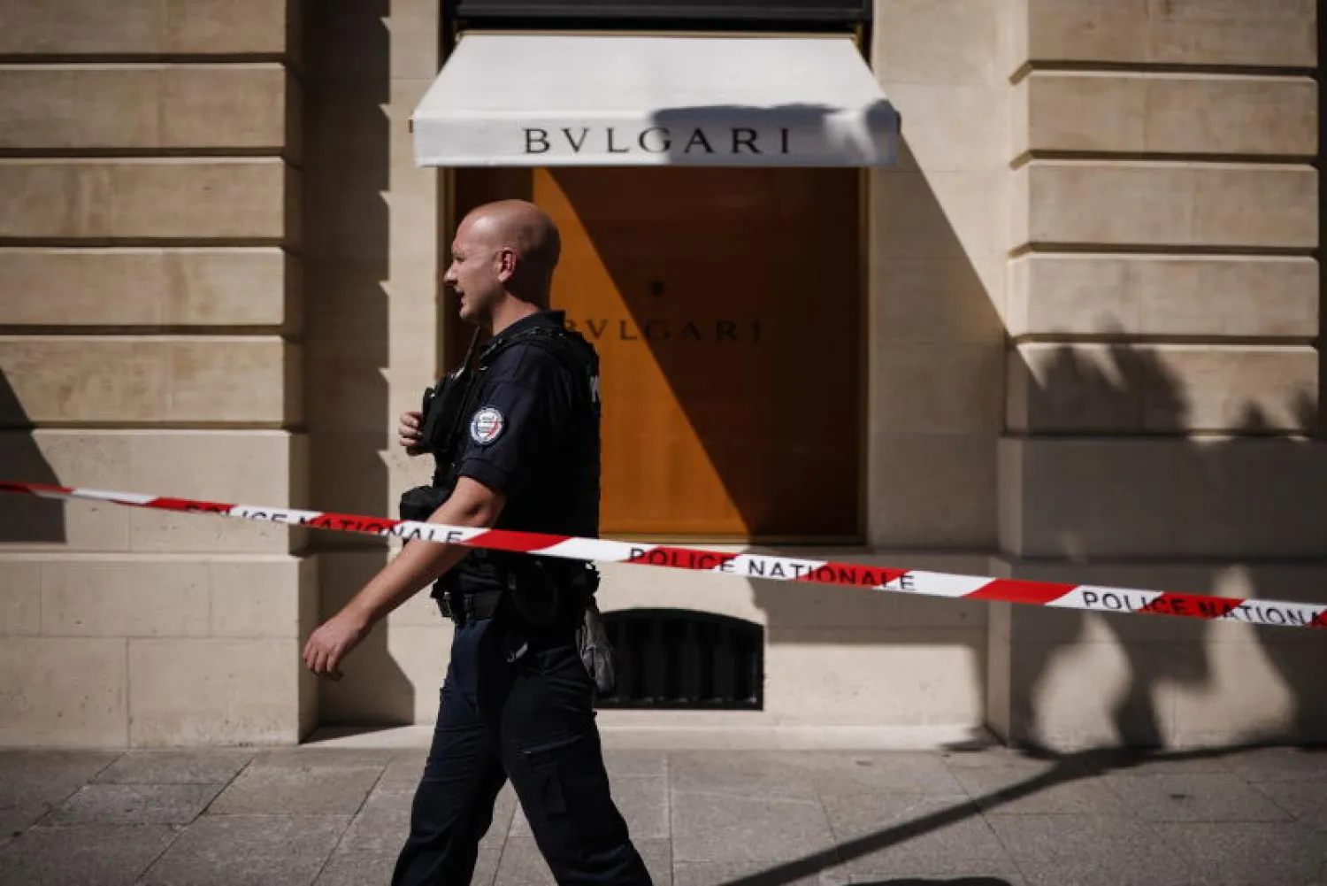 رجل شرطة يسير أمام متجر بولغاري الذي تعرض للسرقة في ساحة فاندوم (إ.ب.أ)