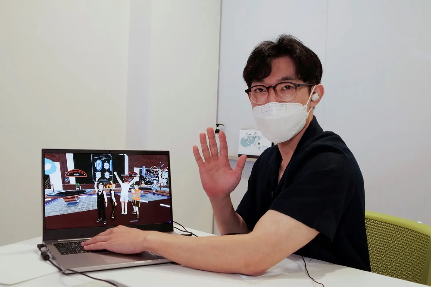Shaun poses for photographs with a laptop showing his avatar in Decentraland in Seoul, South Korea, August 13, 2021. Picture taken on August 13, 2021. (Reuters)