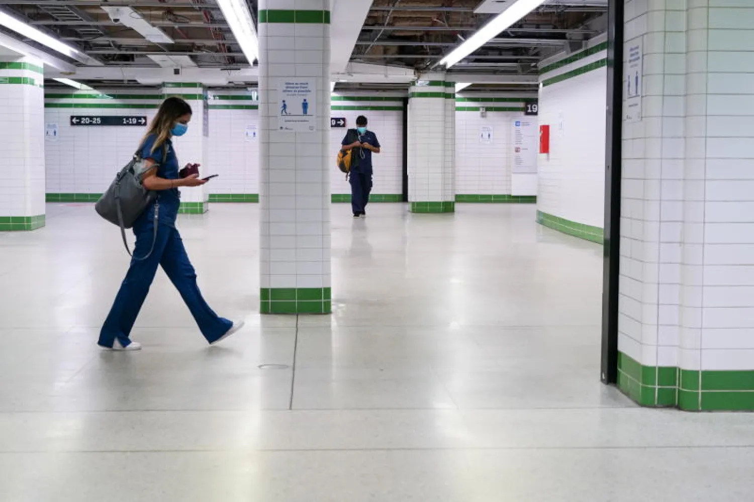 راكبان يضعان قناعين واقيين في المحطة المركزية الفارغة في سيدني (رويترز)