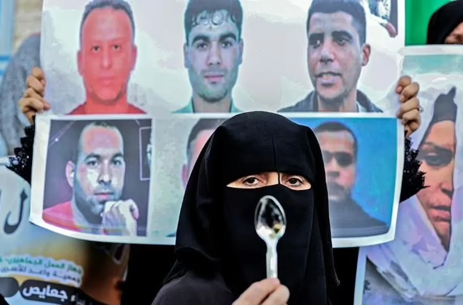 A protester in the Gaza Strip holds a spoon, reportedly the tool six Palestinian prisoners used to dig their way out of Israel's Gilboa prison - AFP