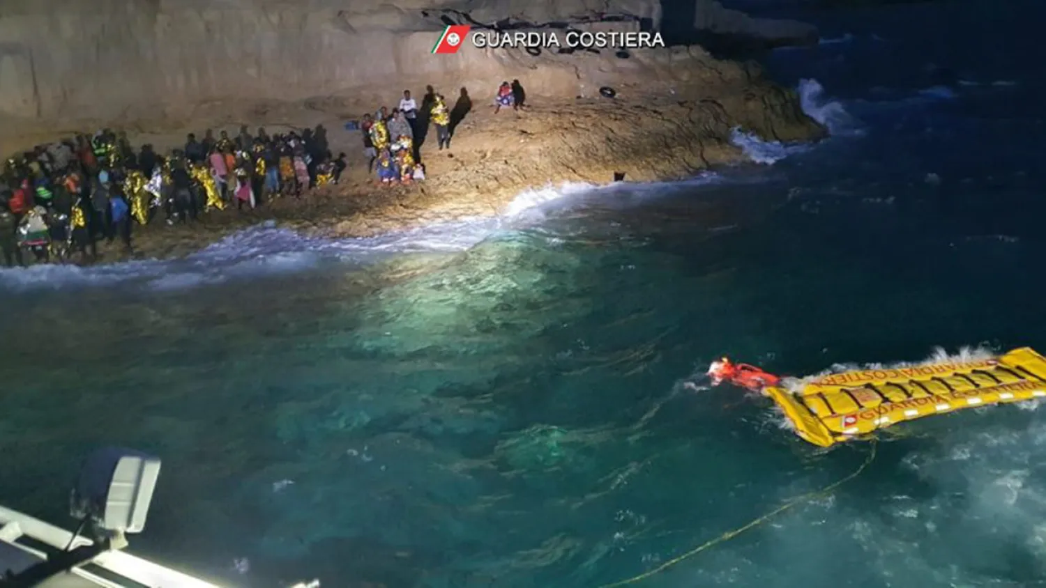 The Italian Coast Guard uses an inflatable raft to rescue migrants stuck on the shore of the Isola dei Conigli island off the Sicilian island of Lampedusa, southern Italy, Thursday, Sept. 9, 2021. (Italian Coast Guard via AP)