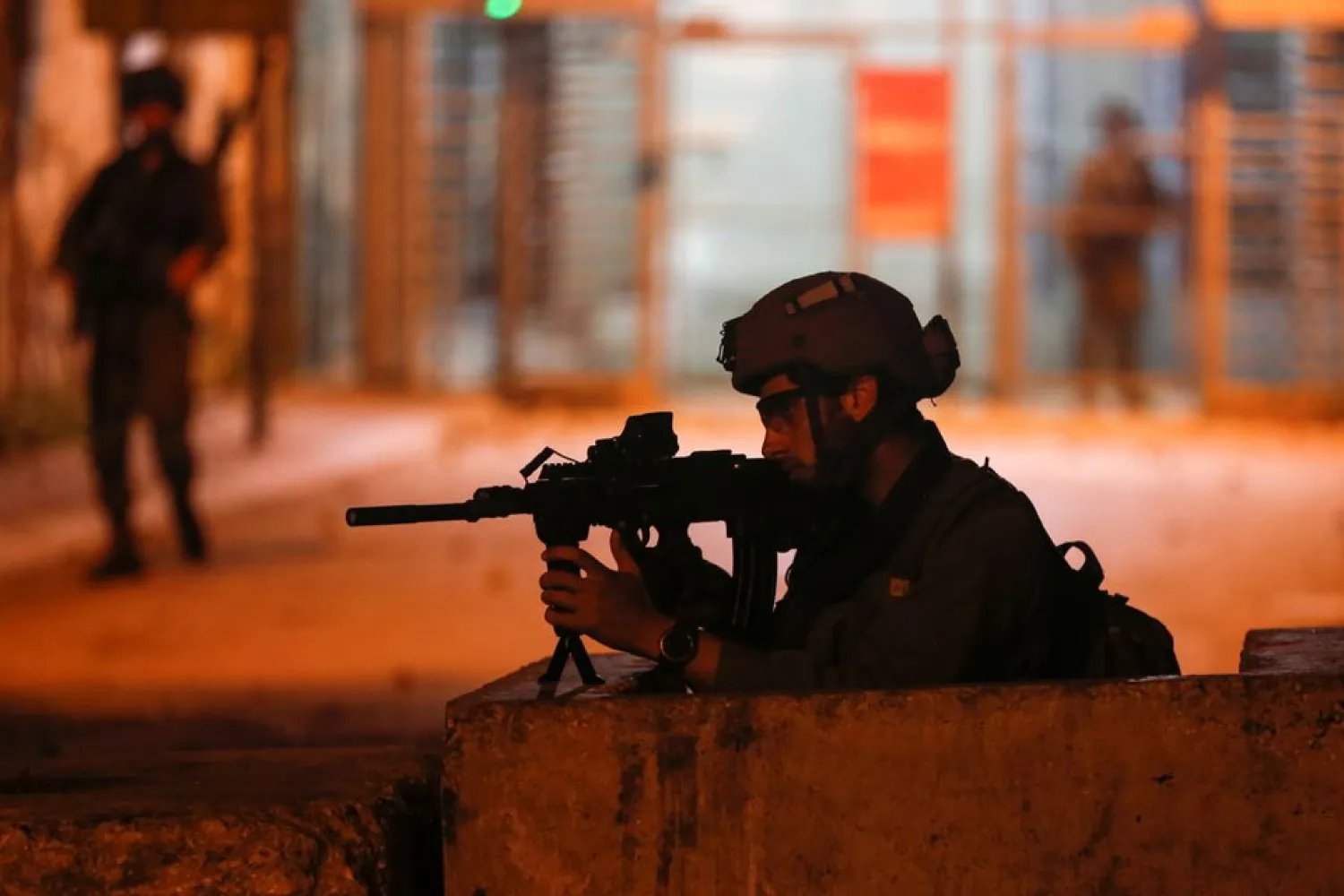 A member of Israeli forces aims his weapon as Palestinians take part in an anti-Israel protest over tension in Jerusalem, in Hebron in the Israeli-occupied West Bank April 24, 2021. (Reuters)