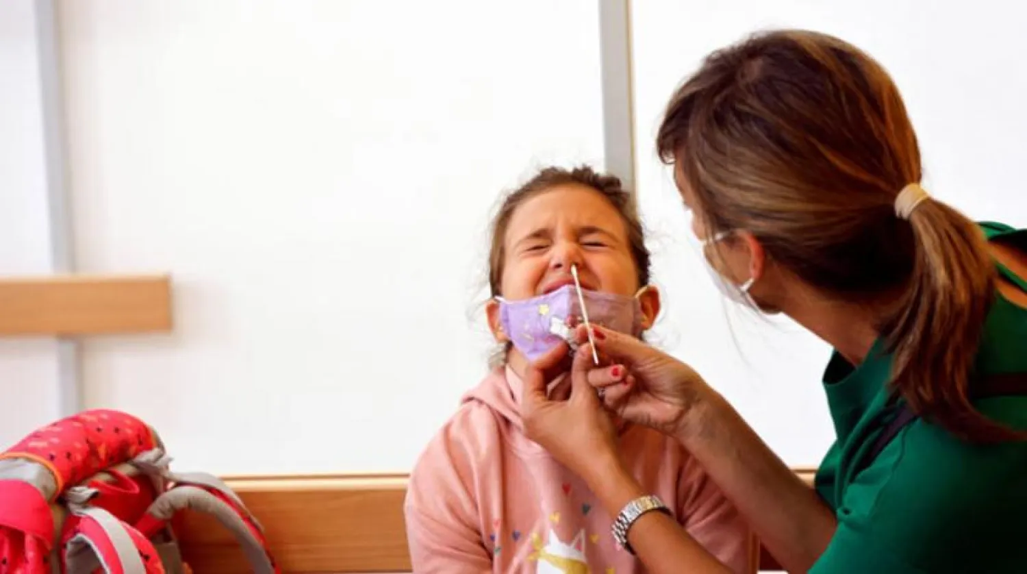 Viyana’daki bir okulda PCR testi yapılan bir çocuk. (Reuters)