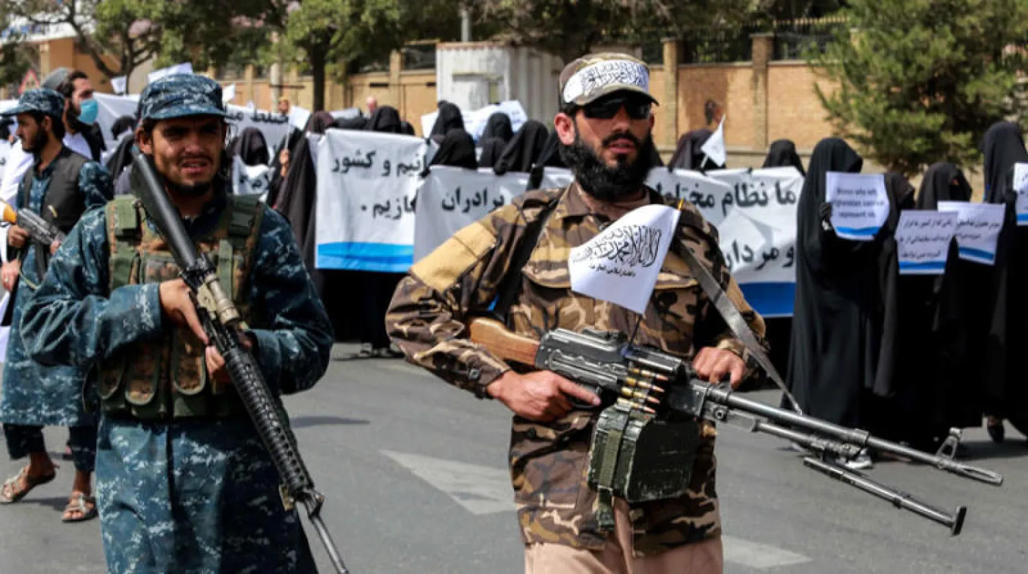 عناصر أمن من {طالبان} يؤمنون مظاهرة لأفغانيات في كابل دعماً لحكومة الحركة (إ.ب.أ)