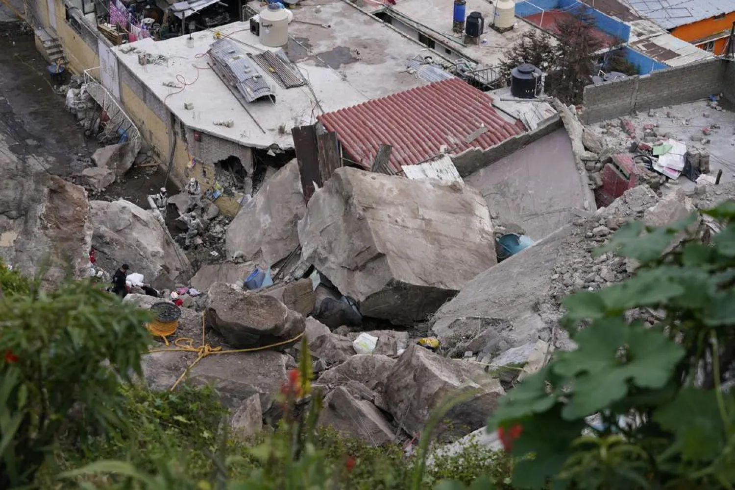 A section of mountain on the outskirts of Mexico City gave way Friday, plunging rocks the size of small homes onto a densely populated neighborhood and leaving at least one person dead and 10 others missing. (AP Photo/Eduardo Verdugo)
