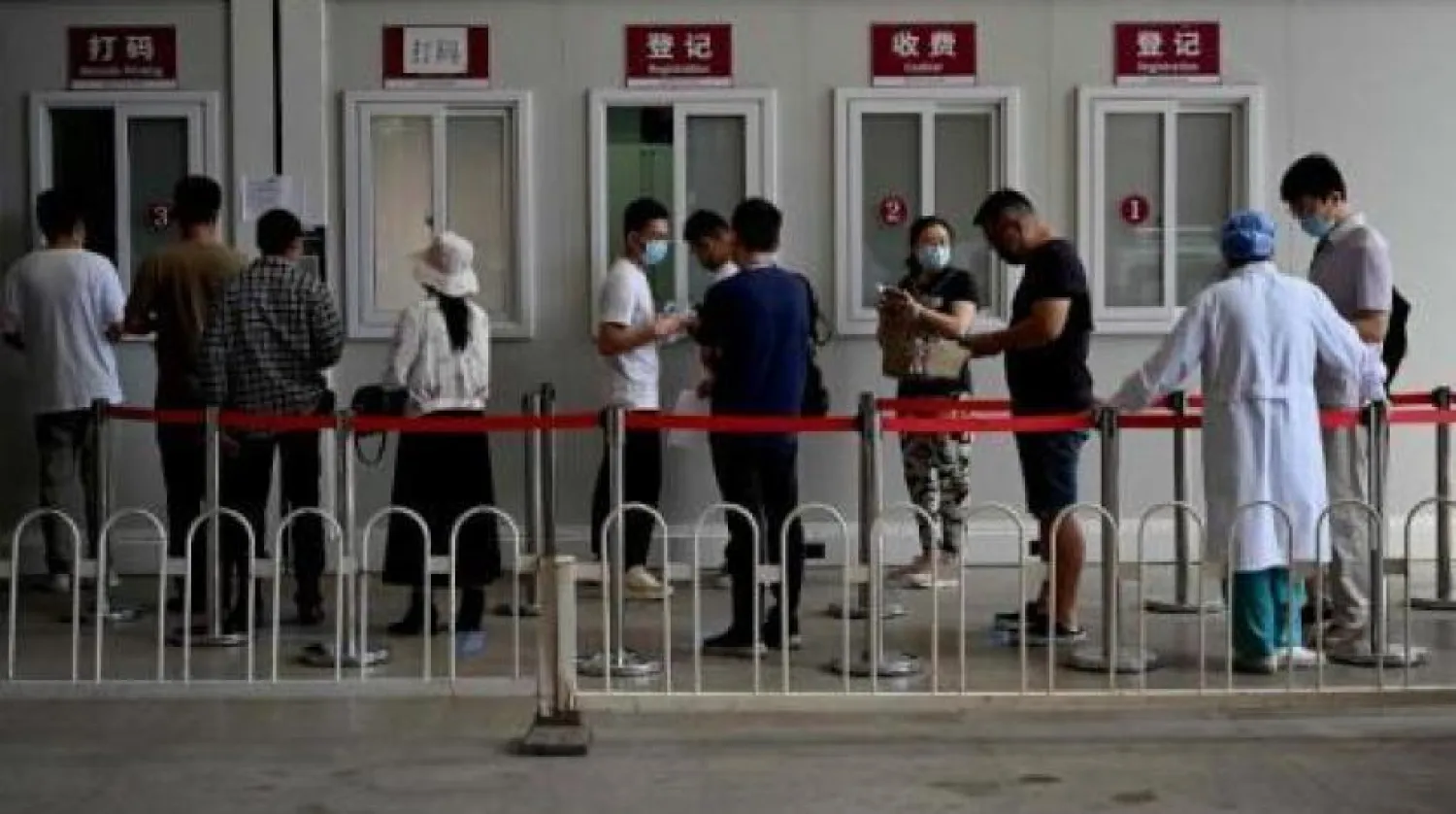 Pekin'deki Chaoyang Hastanesi önünde koronavirüs testi için kuyruğa giren insanlar (AFP)
