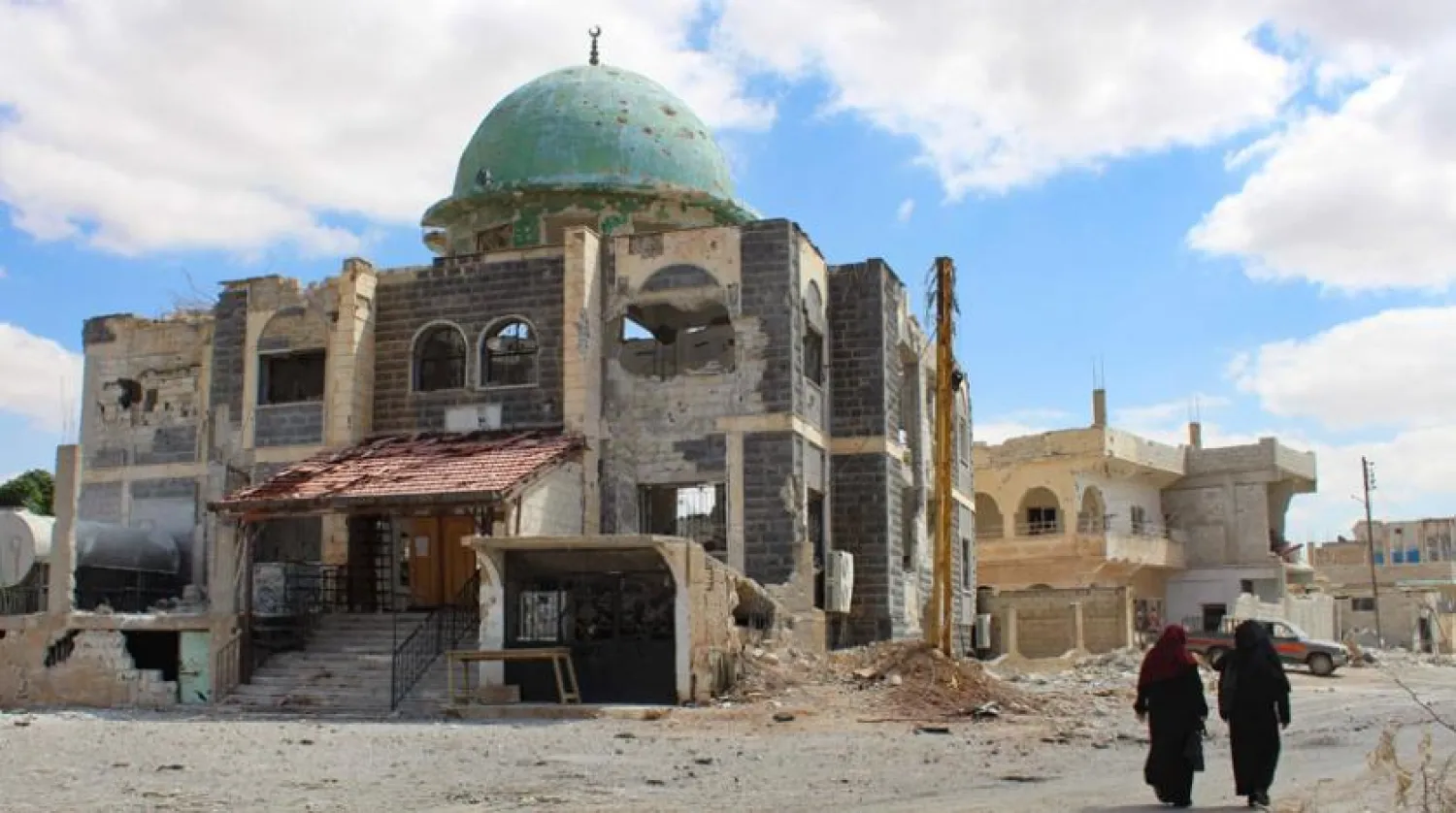 Suriye'nin güneyindeki Dera el-Beled’de dün bir caminin yakınında yürüyen iki kadın (AFP)