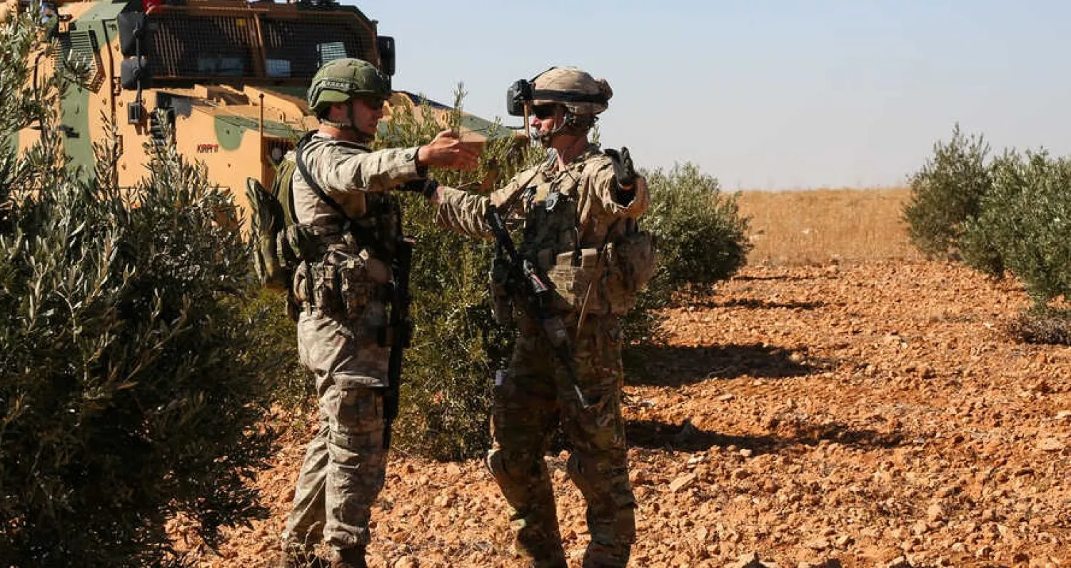 US and Turkish soldiers discuss details during the first-ever combined joint patrol in Manbij, Syria, Nov. 1, 2018. (Courtesy: Arnada Jones/US Army/Handout)
