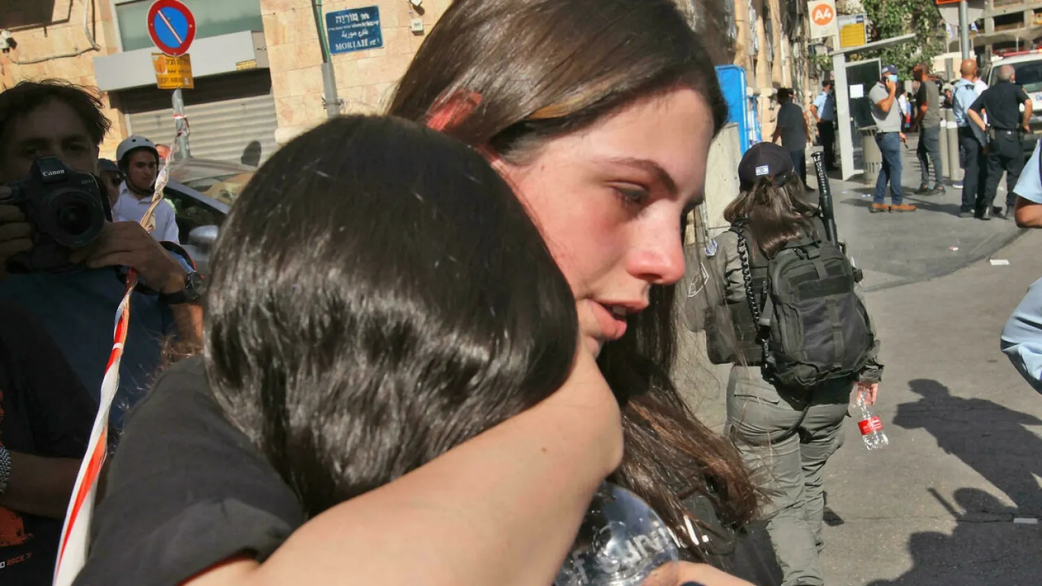 A woman comforts her friend at the scene of a stabbing attack in Jerusalem. (AFP)