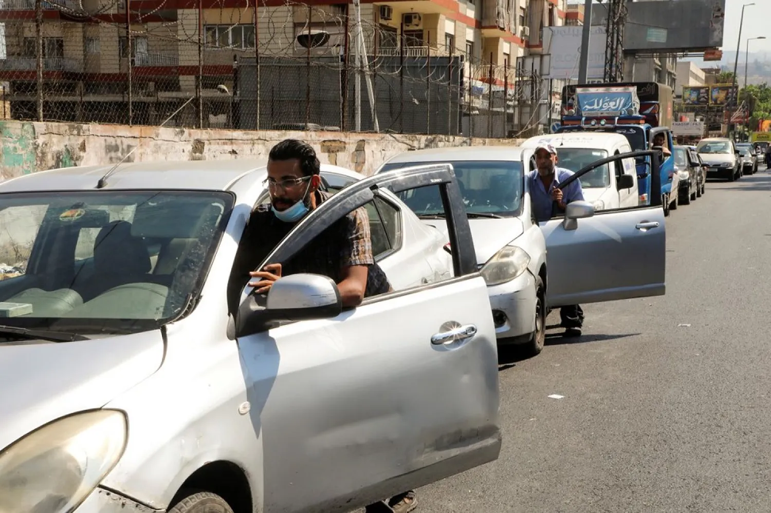 People push their cars due to a lack of fuel, near a gas station in Dora, Lebanon, August 17, 2021. (Reuters)