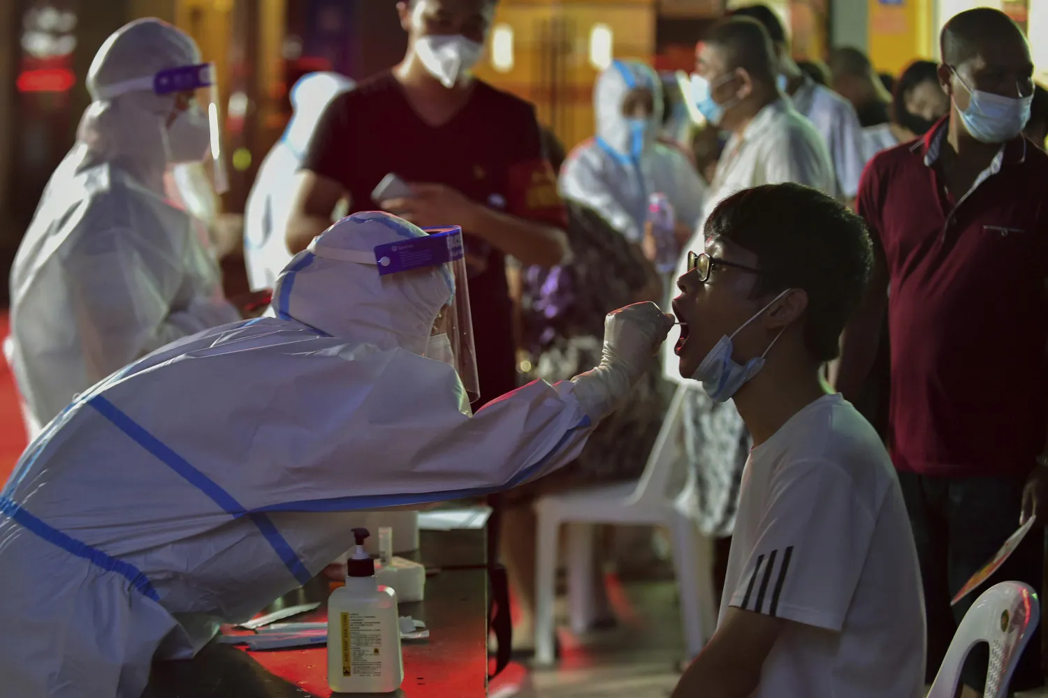In this photo released by Xinhua News Agency, a health worker collects swab sample from a resident during a mass COVID-19 test in Putian in southeast China's Fujian province on Sunday, Sept. 12, 2021. (Wei Peiquan/Xinhua via AP)
