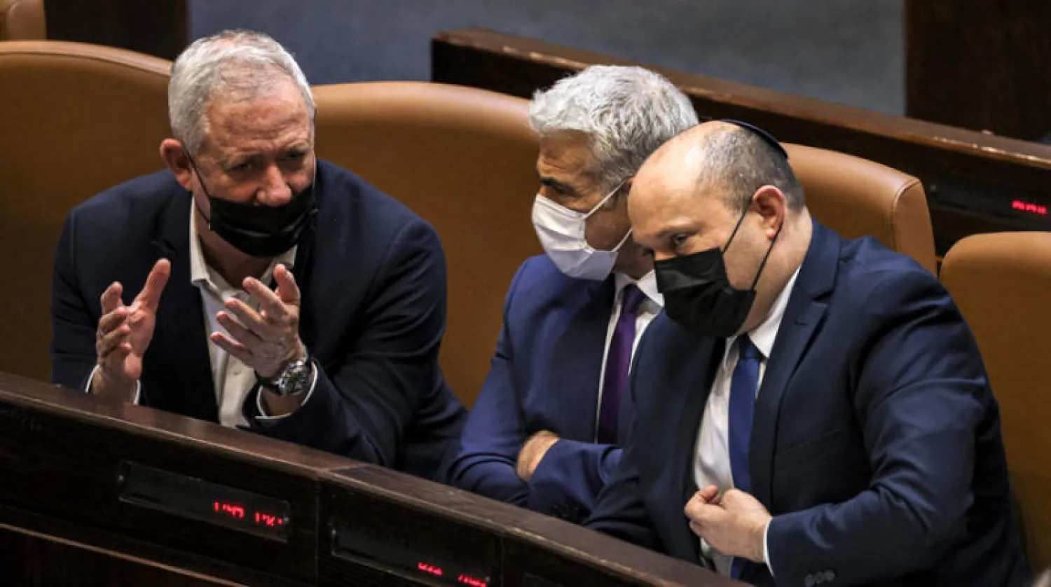 وزير الدفاع والأمن بيني غانتس يتحدث إلى وزير الخارجية يائير لبيد ورئيس الوزراء نفتالي بنيت في اجتماع للكنيست 2 سبتمبر الحالي (أ.ف.ب)