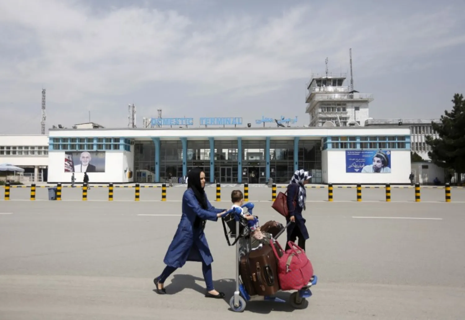 Afghan passengers walk in front of Hamid Karzai International Airport in Kabul (File Photo: Reuters)
