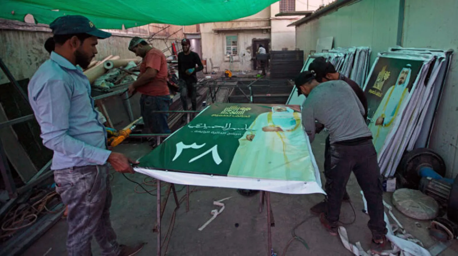 عمال يجهّزون لافتات انتخابية في البصرة الأحد الماضي (أ.ف.ب)