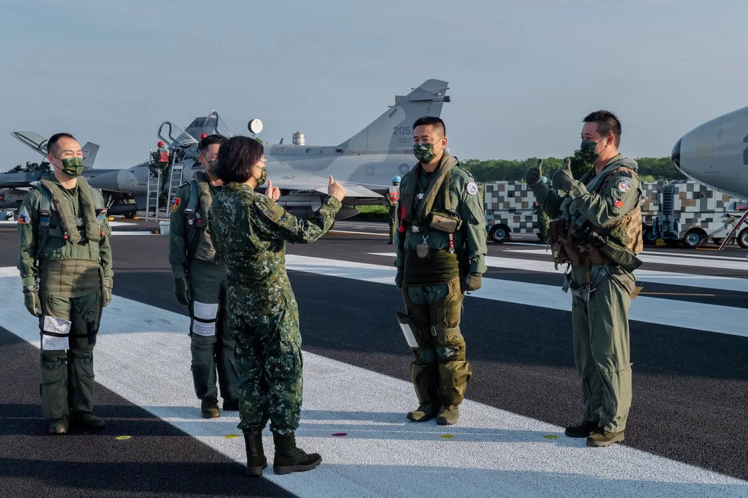 In this photo released by the Taiwan Presidential Office, Taiwanese President Tsai Ing-wen, center, speaks with military personnel near aircraft parked on a highway in Jiadong, Taiwan, Sept. 15, 2021. (AP)
