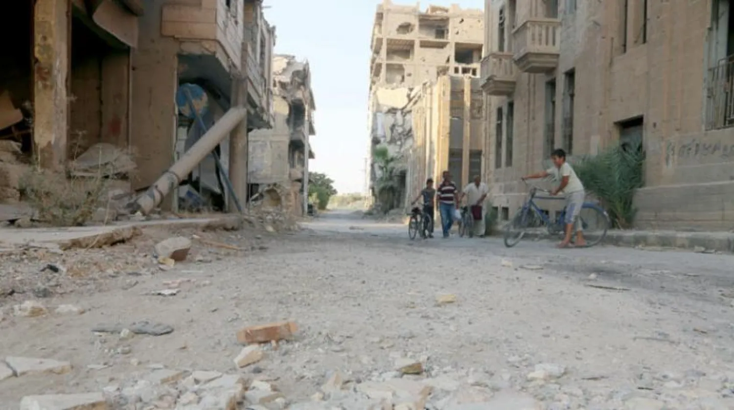 Deyrizor’un sokaklarından birinde yıkılmış binaların arasında görülen bölge sakinleri (Şarku’l Avsat)